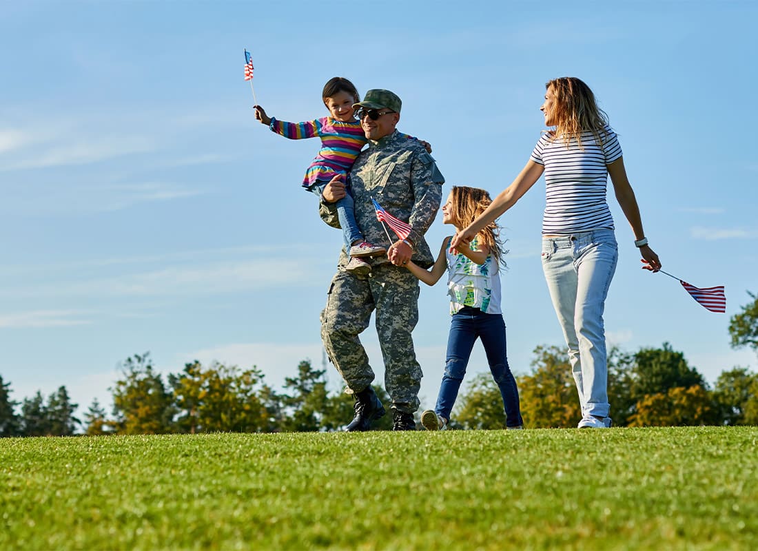 About Our Agency - Soldier With His Family Are Walking With USA Flags